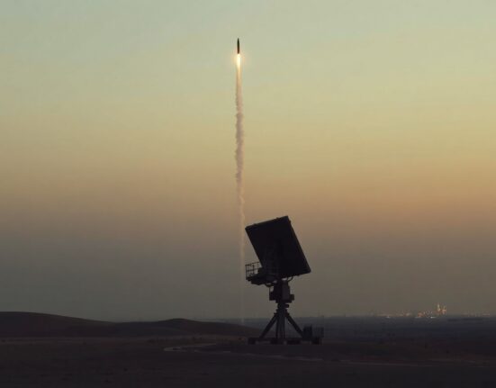 Military radar installation in desert at dusk with interceptor missile trail visible in sky