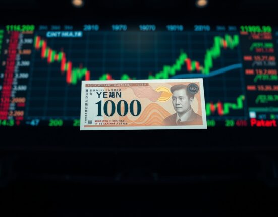 Japanese Yen banknote in focus with blurred financial charts in background representing safe-haven analysis and Danske Bank JPY forecast.