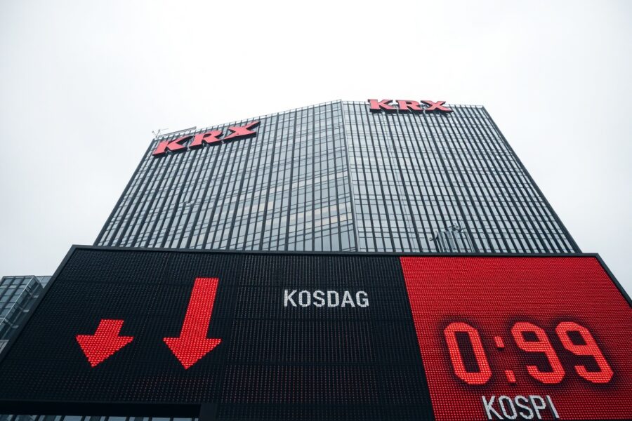 Korea Exchange headquarters in Busan with red stock ticker showing Kosdaq and KOSPI declines