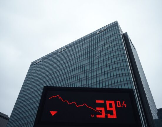 Korea Exchange building in Busan with electronic ticker showing red numbers and downward trend.