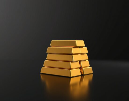 Close-up of polished gold bars on a dark reflective surface with soft studio lighting.