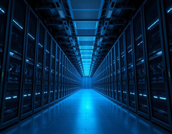 Interior view of a large, modern data center with rows of server racks and blue lighting.