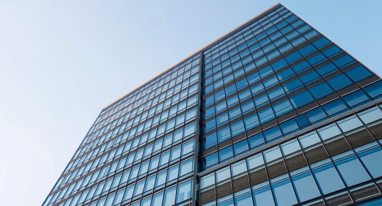 Exterior view of a modern glass office building, representing a global hedge fund headquarters.
