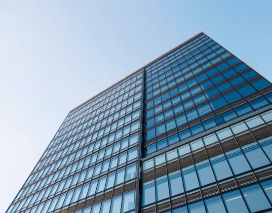 Exterior view of a modern glass office building, representing a global hedge fund headquarters.