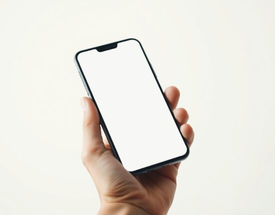 Hand holding a smartphone with a clean screen, representing the merger of Noble Mobile and Helium Mobile.