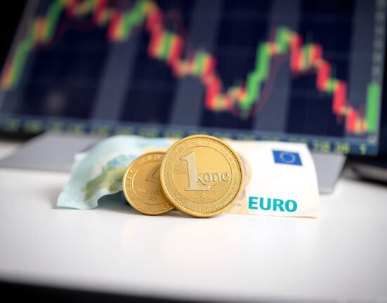 Norwegian krone coins and euro banknotes on a desk, representing the EUR/NOK exchange rate forecast.