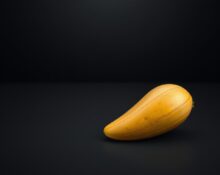 A single ripe mango on a dark tabletop, symbolizing the new MANGOS tech acronym.