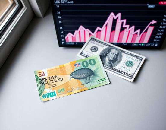 New Zealand dollar and US dollar banknotes on a neutral background, representing the NZD/USD currency pair.