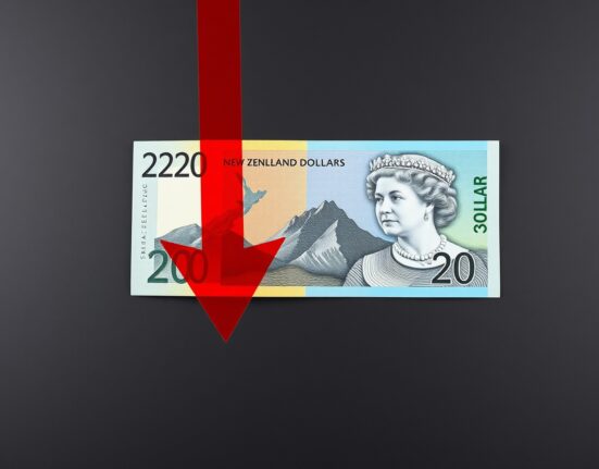New Zealand Dollar banknote with a red downward arrow indicating currency depreciation.