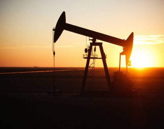 Oil pumpjack silhouetted at sunset in an oil field, representing crude oil supply and demand dynamics.
