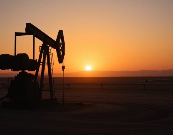 Oil pumpjack in desert at sunset representing crude oil market stability