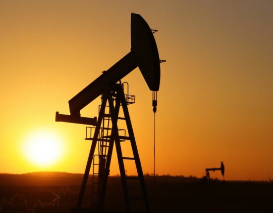 Oil pumpjack at sunset with financial chart and currency symbol overlays representing market shifts.