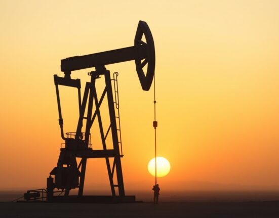 Oil pumpjack silhouette at sunset representing easing geopolitical tensions and falling oil prices