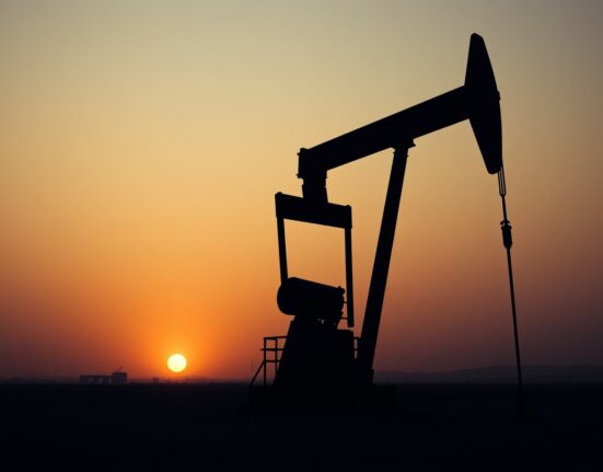 Crude oil pumpjack in a desert oil field under a hazy sky, representing geopolitical risk supporting oil prices.