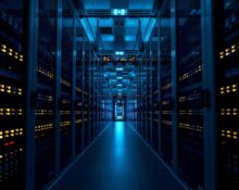 Server racks in a modern data center with blue and amber LED lights, representing AI infrastructure.