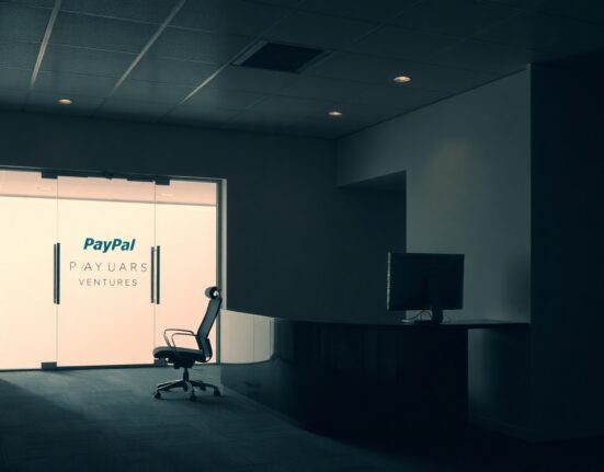 Empty office lobby of PayPal Ventures with dim lighting and a closed reception desk