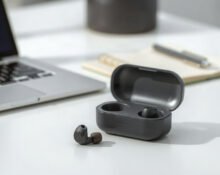 Plaud One earbuds and charging case on a desk