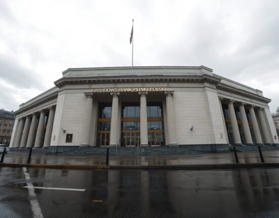 Narodowy Bank Polski building in Warsaw on a cloudy day, representing Poland's monetary policy stance.