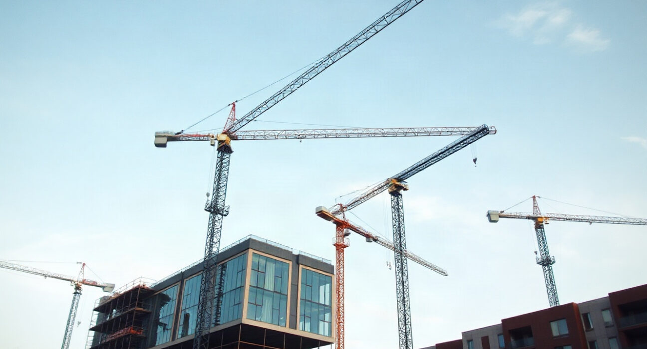 Construction cranes over new buildings in Poland, representing investment rebound and economic growth