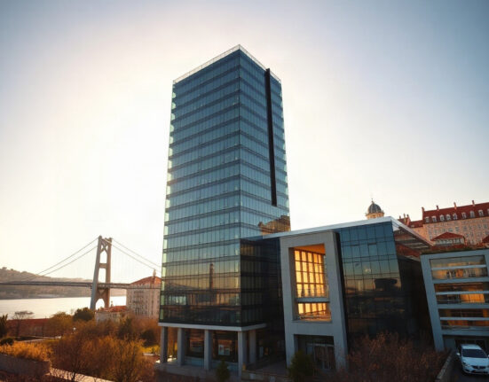 Lisbon skyline with modern office buildings and the 25 de Abril Bridge, symbolizing economic growth