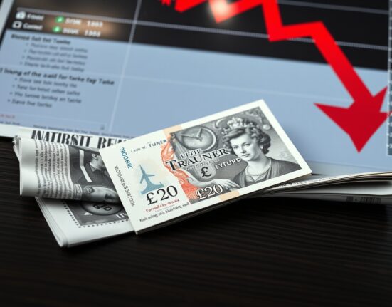 British Pound Sterling banknote on a financial chart with a downward red arrow