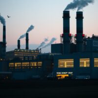 Industrial factory complex in Russia at dusk with smokestacks and lights on