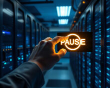 Hand pressing a pause button in a data center, representing AI development slowdown.
