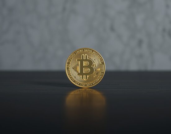 Bitcoin coin on dark wooden surface with soft lighting