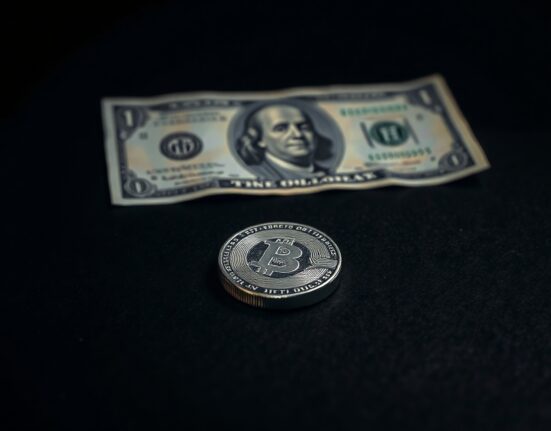 Silver bullion coin on dark surface with US dollar bill reflection, representing falling silver prices after jobs report