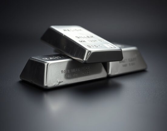 Close-up of silver bars on a dark reflective surface with soft studio lighting.
