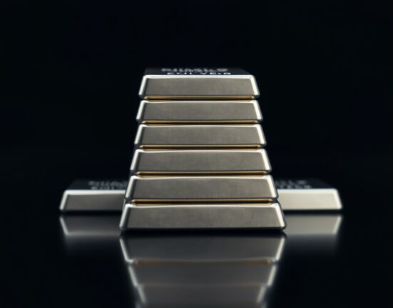 Close-up of polished silver bars on a dark reflective surface with soft studio lighting.