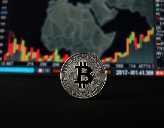 Silver bullion coin on dark surface with financial news background