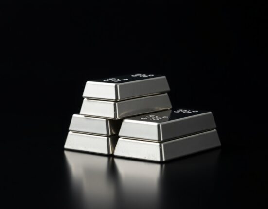 Stack of polished silver bullion bars on dark reflective surface