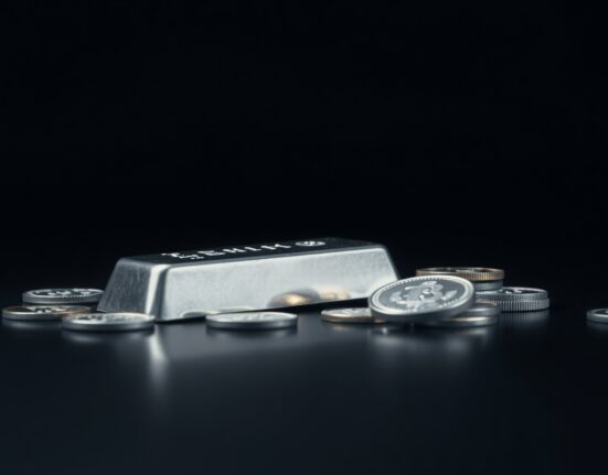 Silver bars and coins on a dark surface representing precious metals market analysis