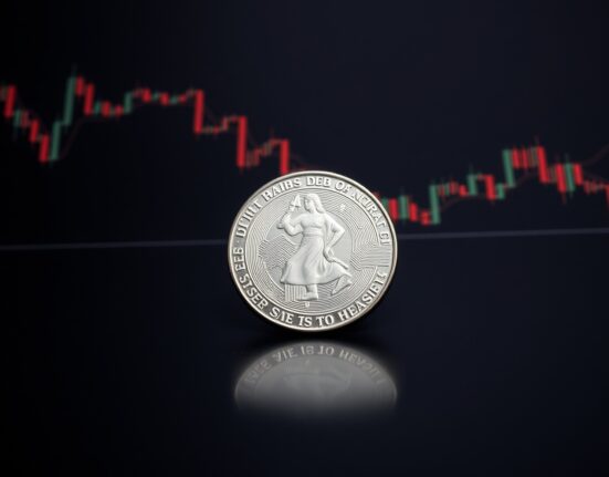 Silver bullion coin on reflective surface with bearish chart overlay, representing XAG/USD price forecast.