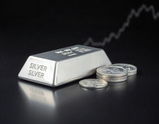 Silver bullion bars and coins on a reflective surface, representing the precious metal's price movement.
