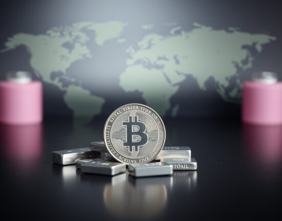 Silver coins and bars on reflective surface with blurred map background