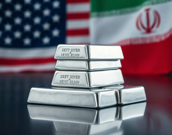 Silver bullion bars on reflective surface with blurred US and Iranian flags in background