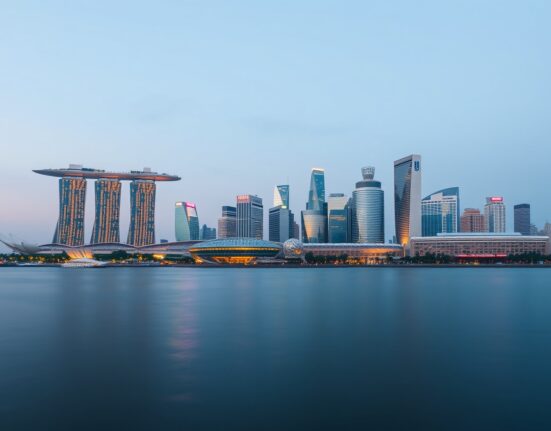 Singapore skyline at dusk with Marina Bay Sands and financial district, illustrating economic and policy analysis.