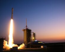SpaceX Falcon 9 rocket launching at dusk with bright exhaust against dark sky