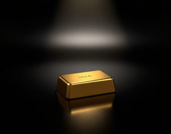 A polished gold bar on a dark surface, representing the spot gold price drop below $4,600 per ounce.