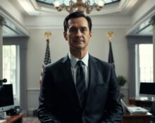 Sriram Krishnan, White House AI advisor, standing at a podium in a government office.