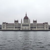 Hungarian Parliament building in Budapest, Hungary, on a cloudy day, representing economic policy and the Forint.
