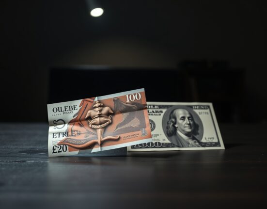 British pound and US dollar banknotes on a dark desk, illustrating currency market tension.