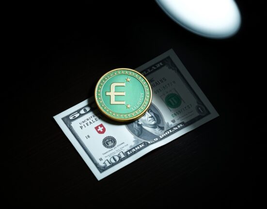 Swiss Franc coin and US Dollar bill on a desk, representing currency market analysis.