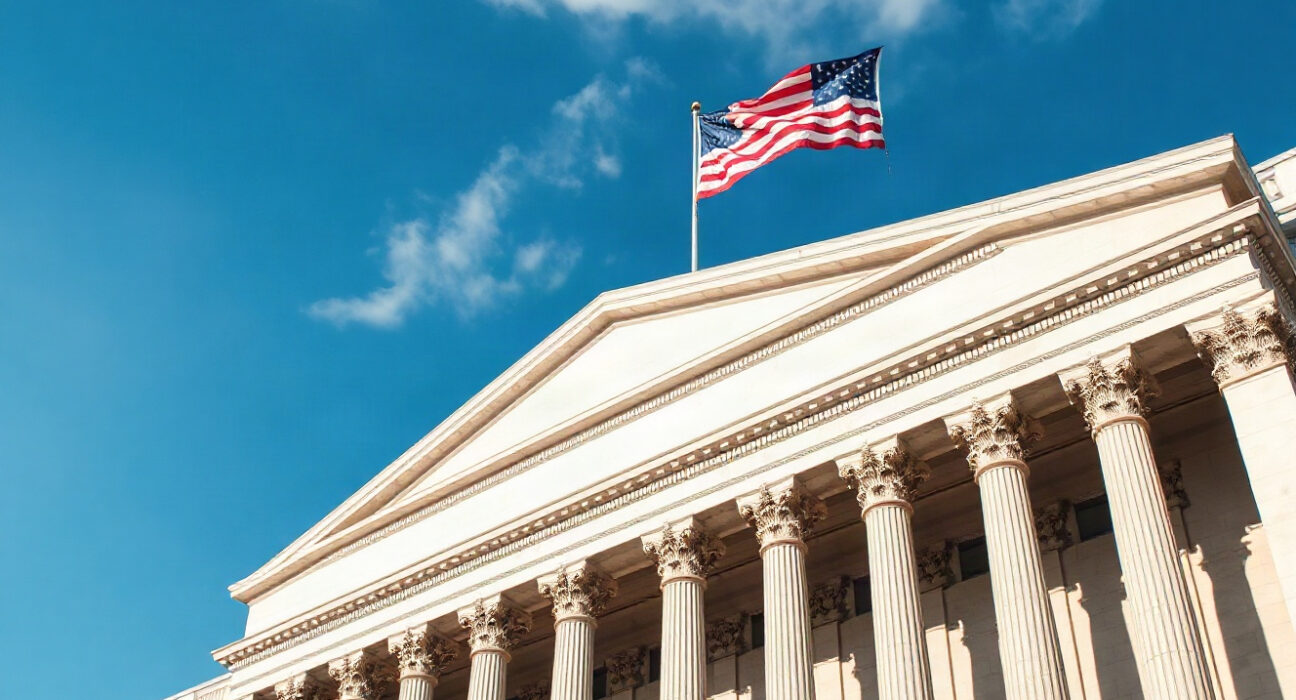 U.S. Treasury Building in Washington, D.C., on a sunny day with American flag flying.