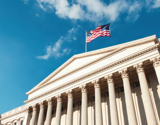 U.S. Treasury Building in Washington, D.C., on a sunny day with American flag flying.