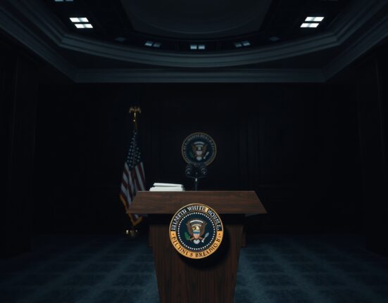 Empty White House press briefing room with presidential seal on podium, awaiting President Trump's address on Iran tensions.