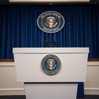 White House press briefing room podium with presidential seal, representing official US government statement on Iran policy.