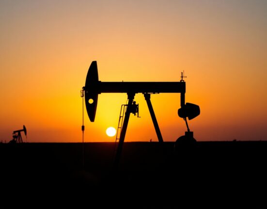 Oil pumpjack silhouetted against a sunset, symbolizing energy markets and inflation concerns.
